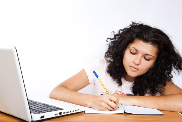 A student writing on a notebook