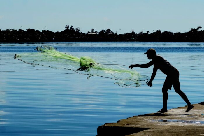 Man throwing fishnet in the river