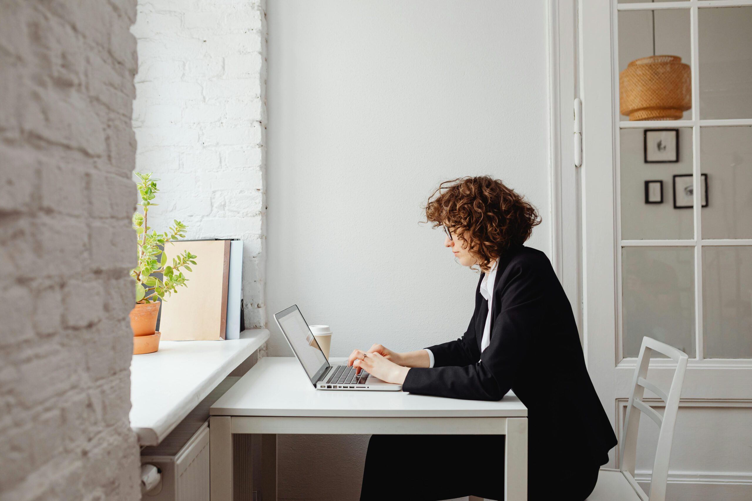Business woman at white desk on laptop