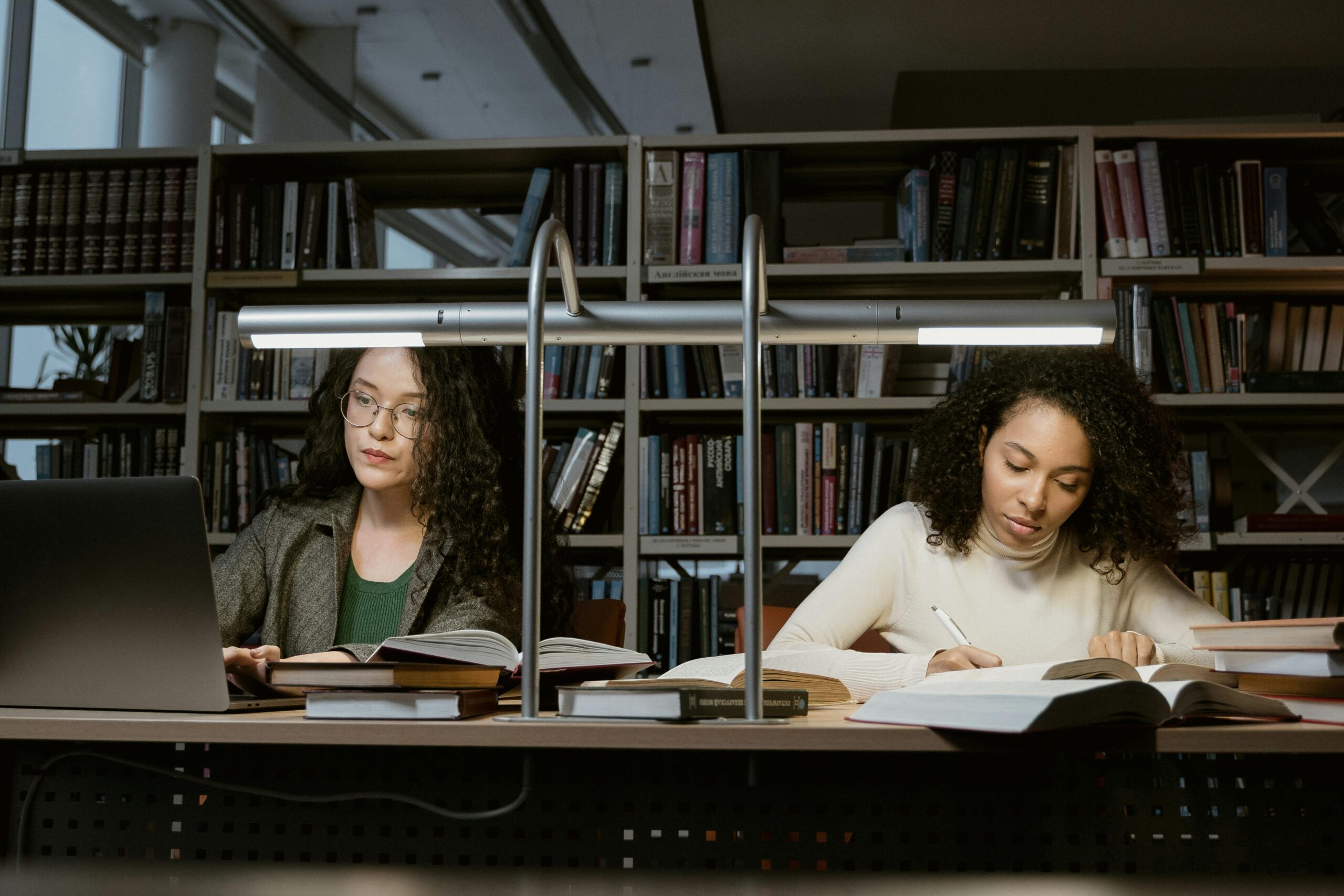 two young women studying in library
