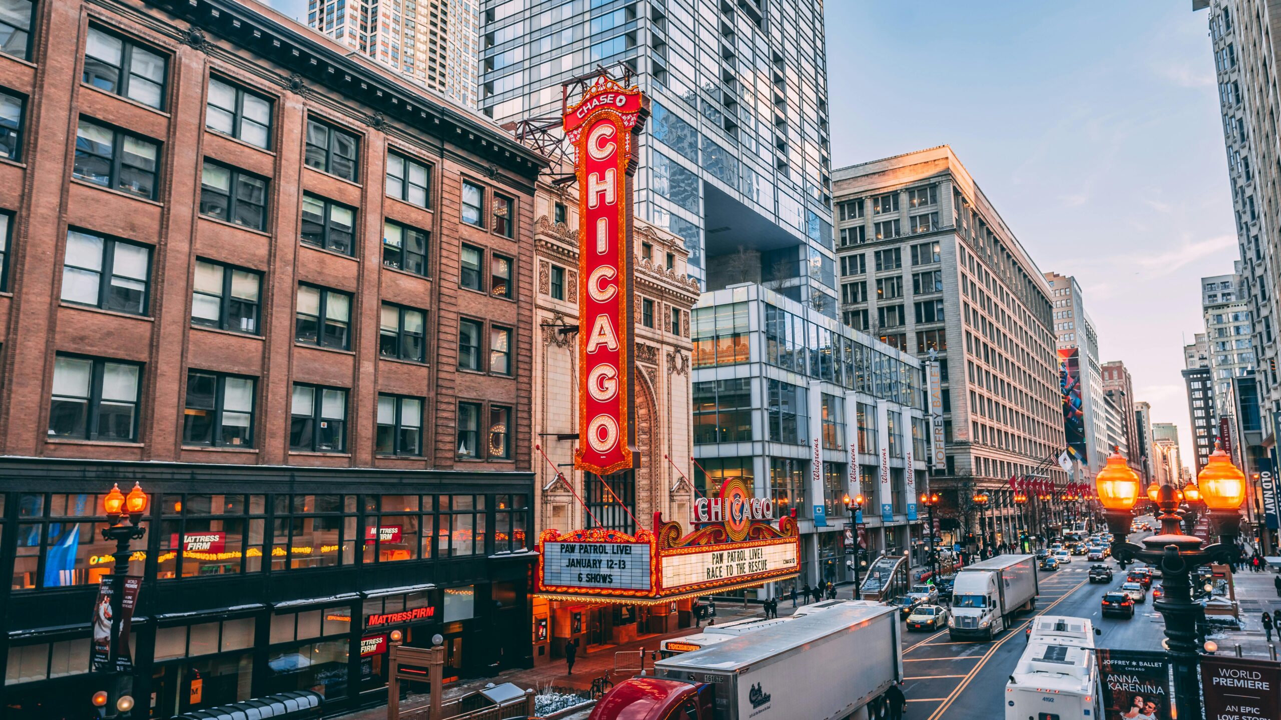 City street with large vertical theater sign that says Chicago in bright lights