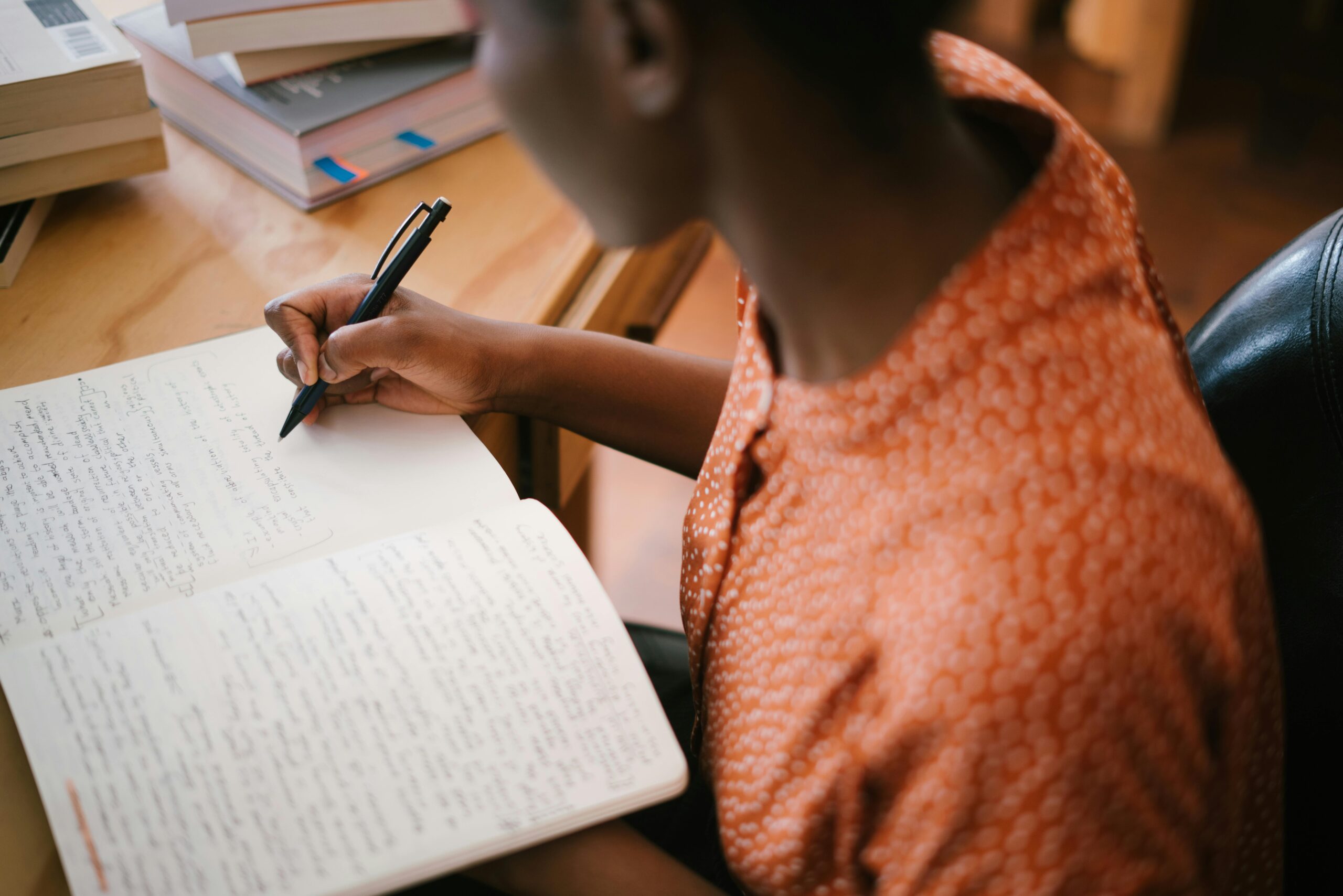 Student leaning over a notebook writing notes