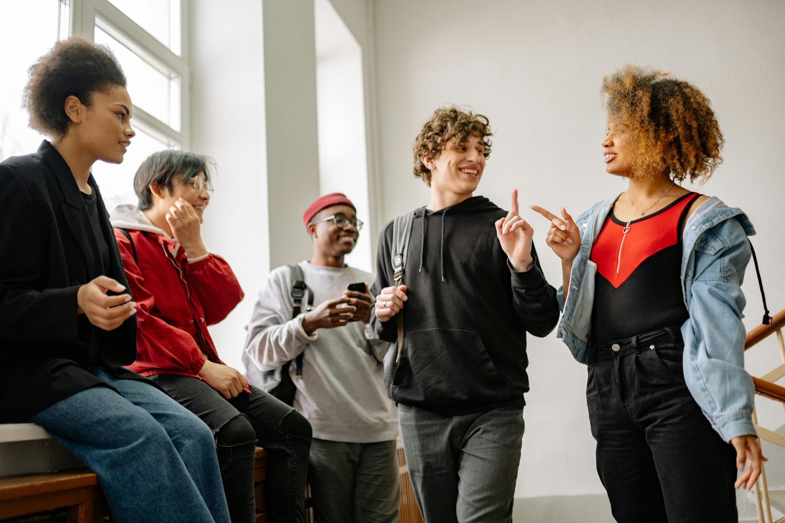 Group of students in discussion in hallway next to window