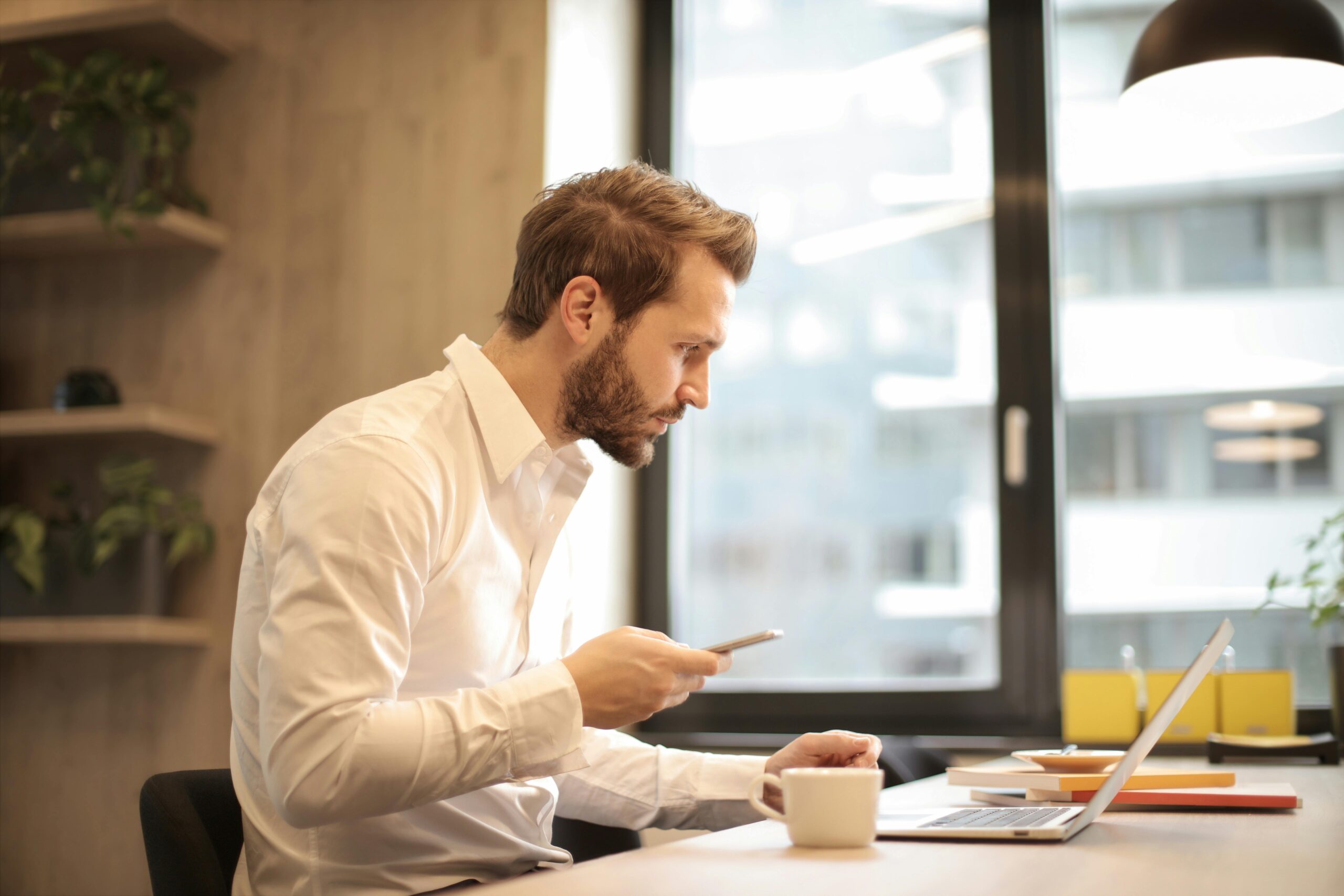 Business person sitting at table working on laptop at a coffee shop