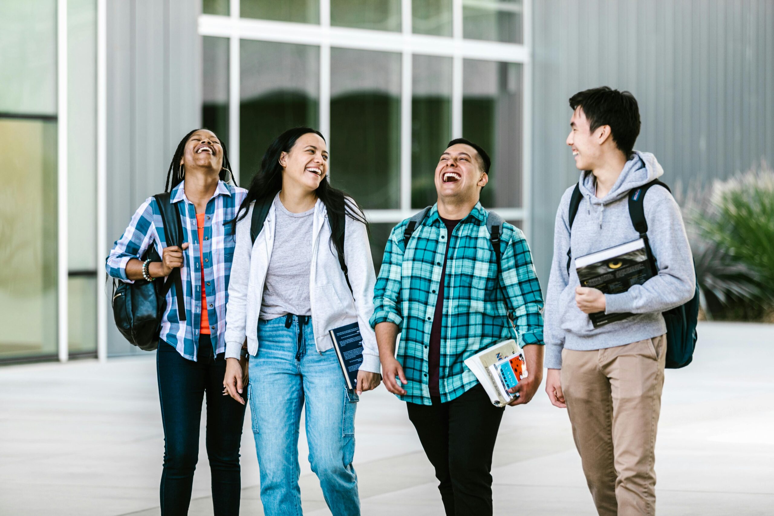 Four students walking and laughing with each other
