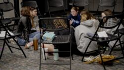 a group of girls sitting in a room next to each other