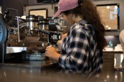 a woman working on a machine in a coffee shop